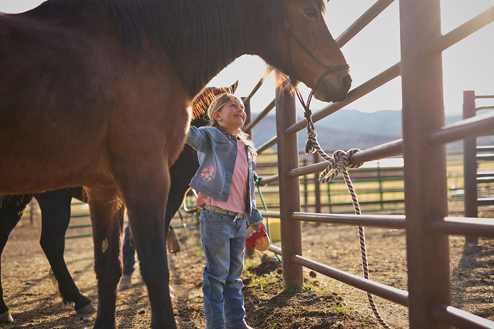 Rural1st_2025_0818_Website_BodyImage_960x640_ElieseAndRonGhaffari_FINAL Aspen Ghaffari smiles at one of her horses on the Ghaffari family property in Montrose, CO