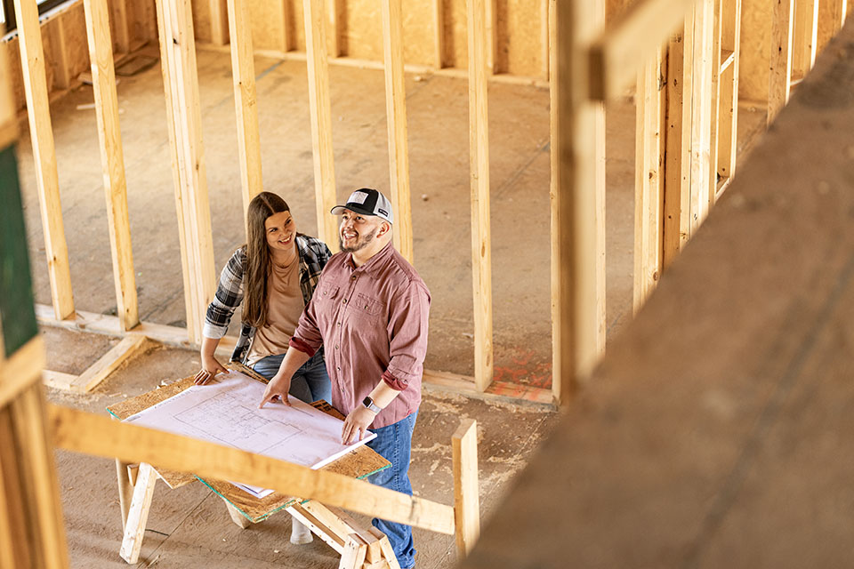 Couple look at blueprints for rural home construction financed by Rural 1st.