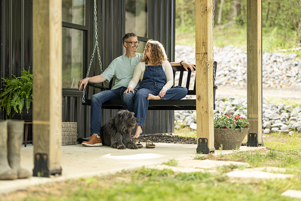 Couple sitting on porch of barndo financed by Rural 1st.