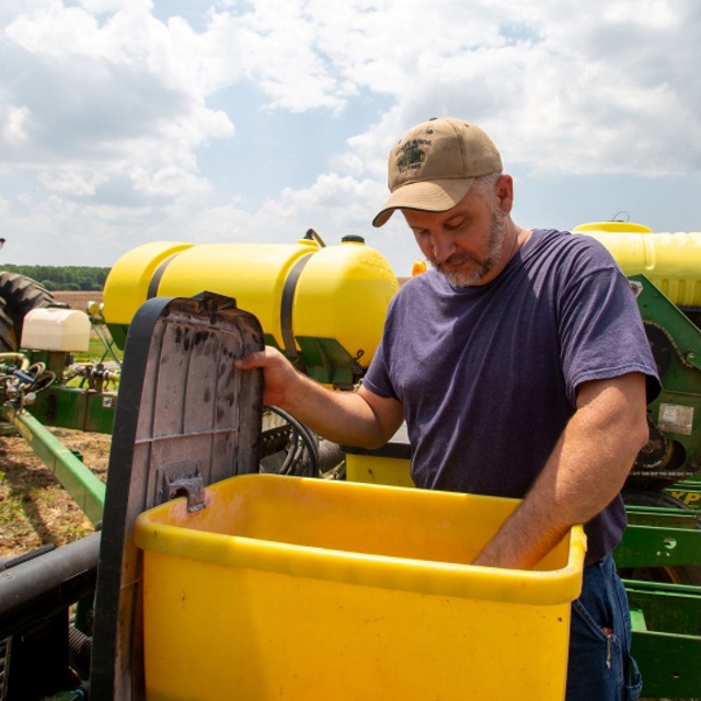 Farm checking seed bought with farm loans from Farm Credit Mid-America.